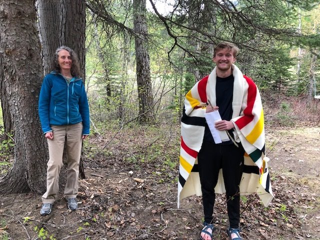 Andrew David and supervisor Kelly Lynch at Glacier National Park. Andrew was gifted a Pendleton blanket, a traditional Native American gift of honor, for his service.